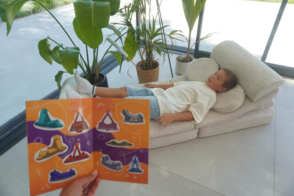 Beigelegtes Aufkleberheft mit Bauideen neben dem aufgebauten Linodino Spielsofa