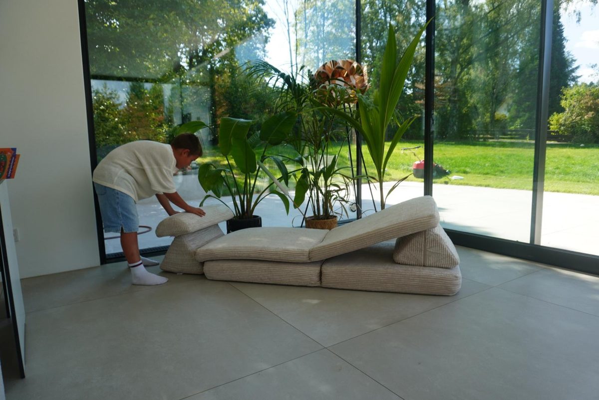 Kind baut das Linodino Spielsofa Spielparadies in Elfenzauber Beige zur Liege um